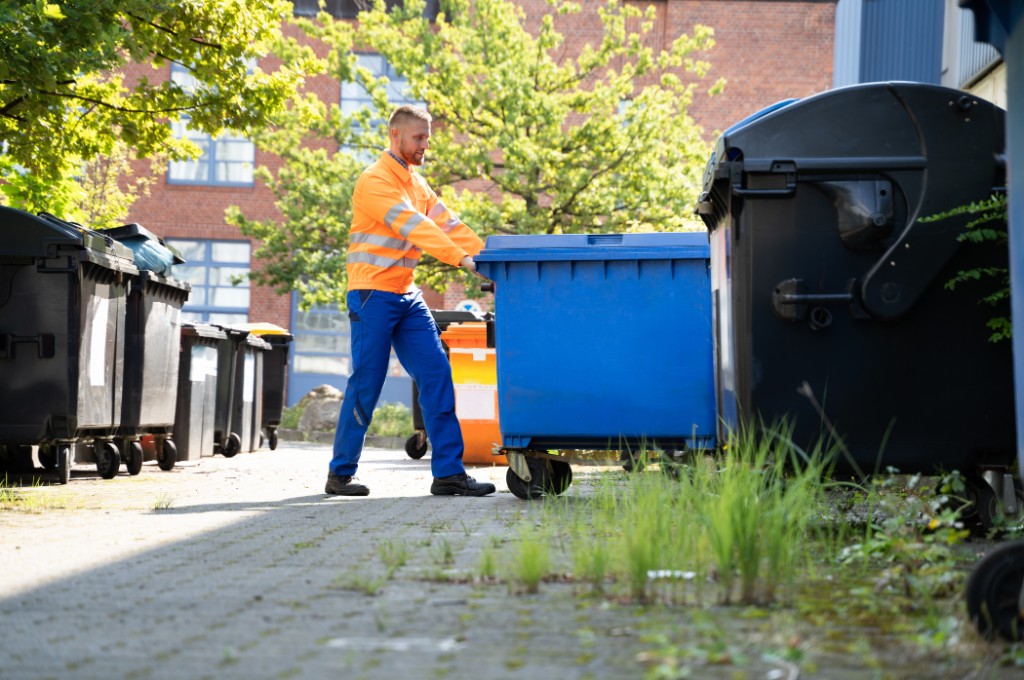 Worker moving trash bins for property reset